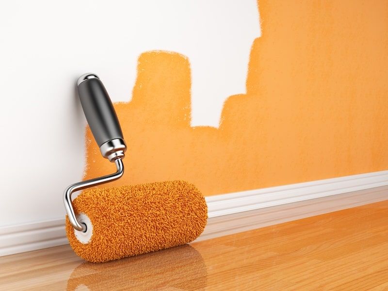 orange paint roller next to a wall