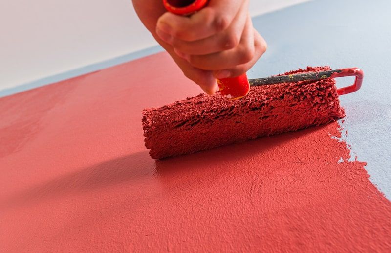 roller being used to paint a wall