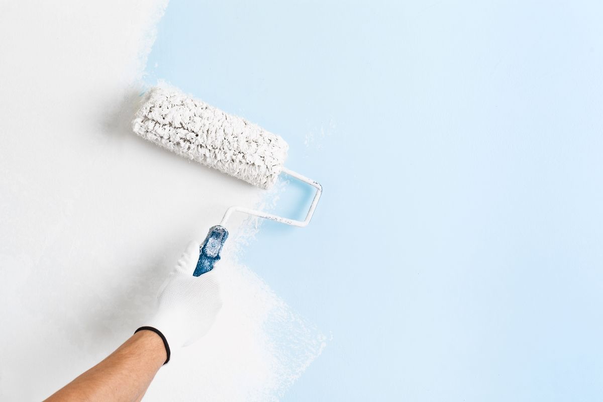 a blue wall being painted white