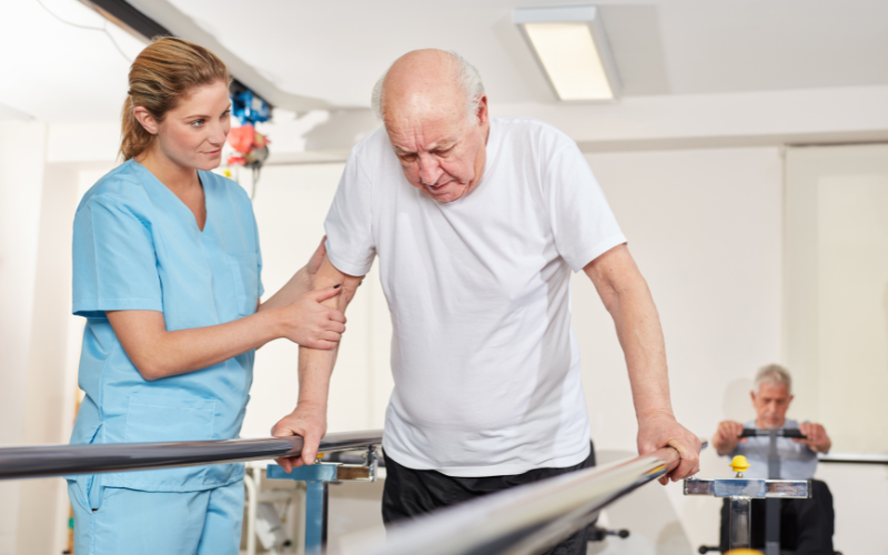 a nurse helping an aged man exercise