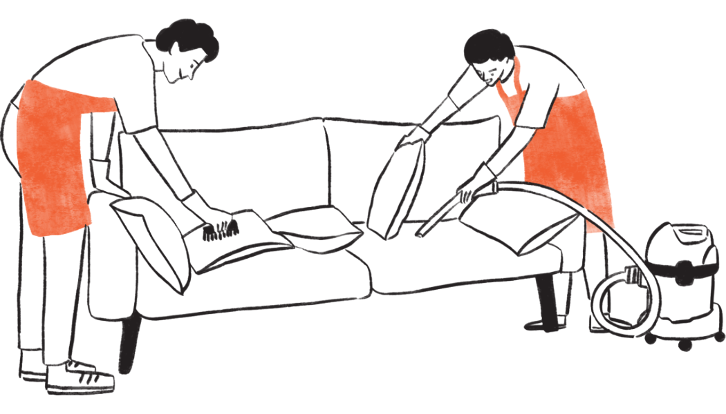 2 guys cleaning the sofa themselves using a vacuum cleaner