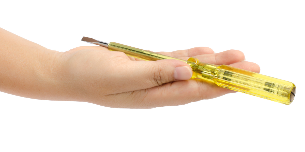 a person holding out a flat head screwdriver