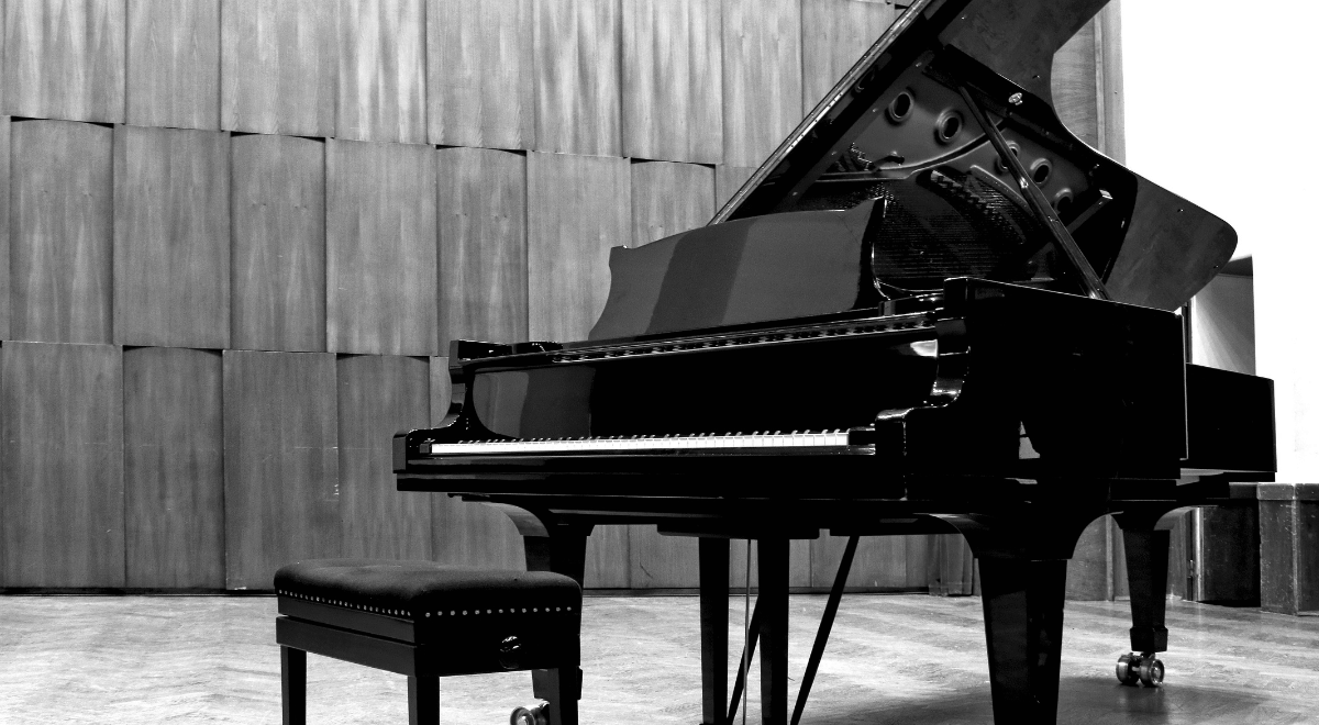 Black and white picture of a piano in an empty room