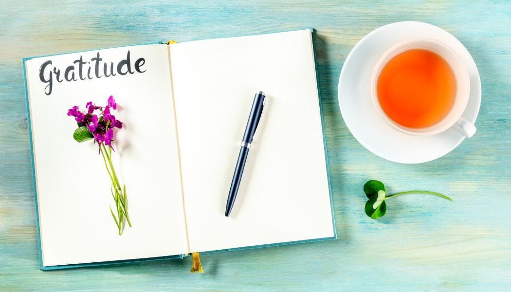 Gratitude Journal with a Pen, a Flower, and a Cup of Tea