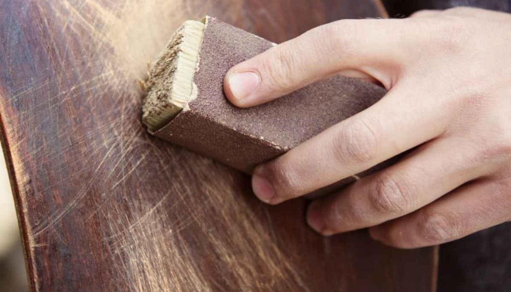 a person using sandpaper to fix wood