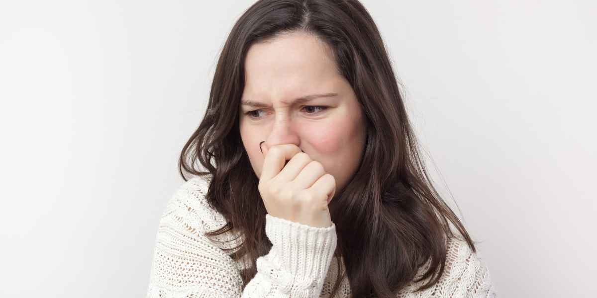 Woman closing nose due to bad odor