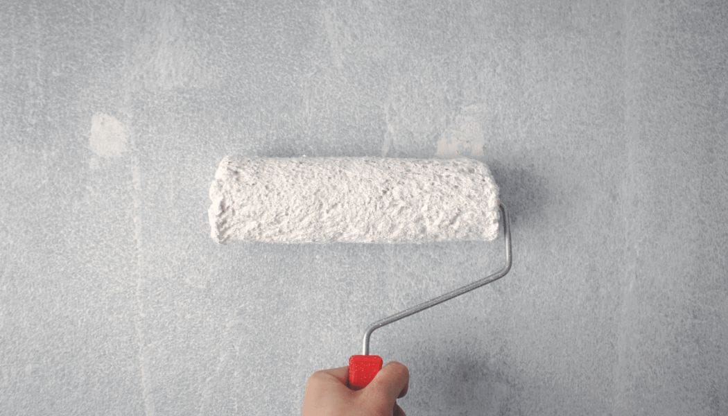 white colour roller paint painting a wall