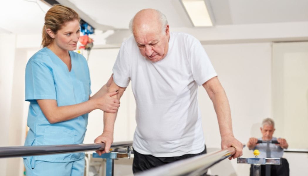 a nurse helping an aged man exercise