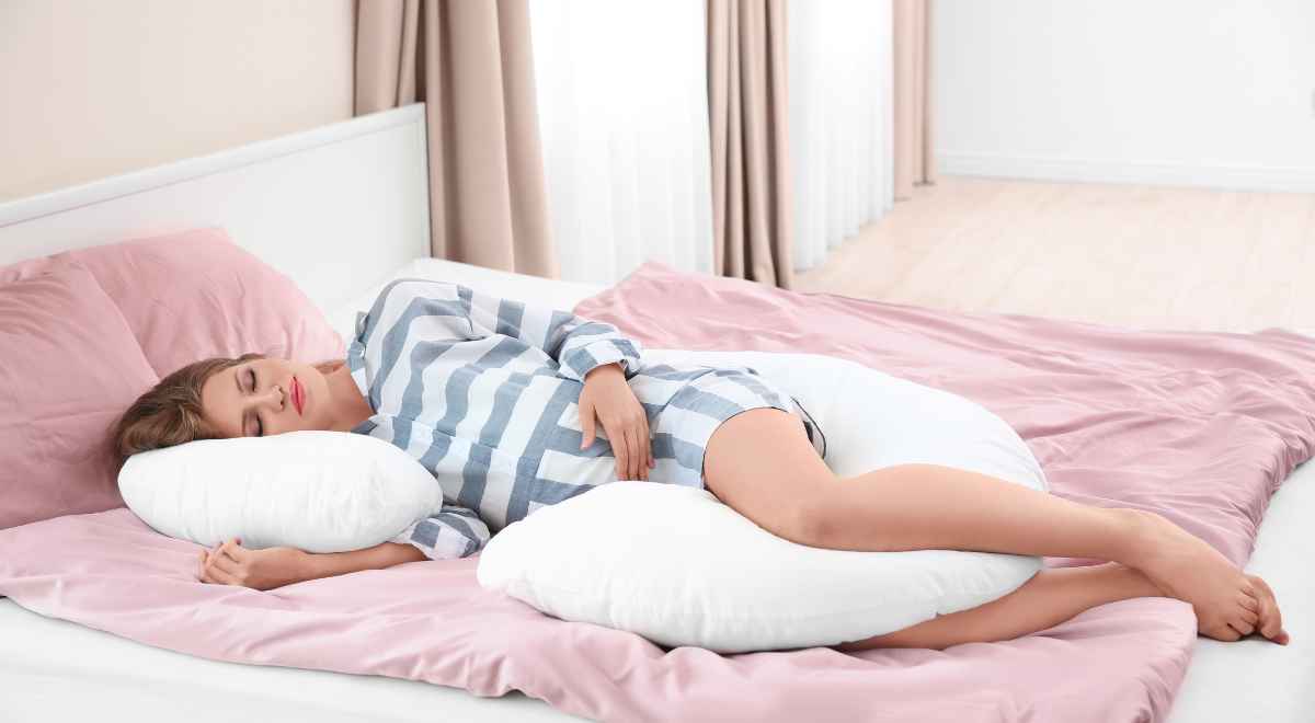A pregnant woman using a pregnancy pillow