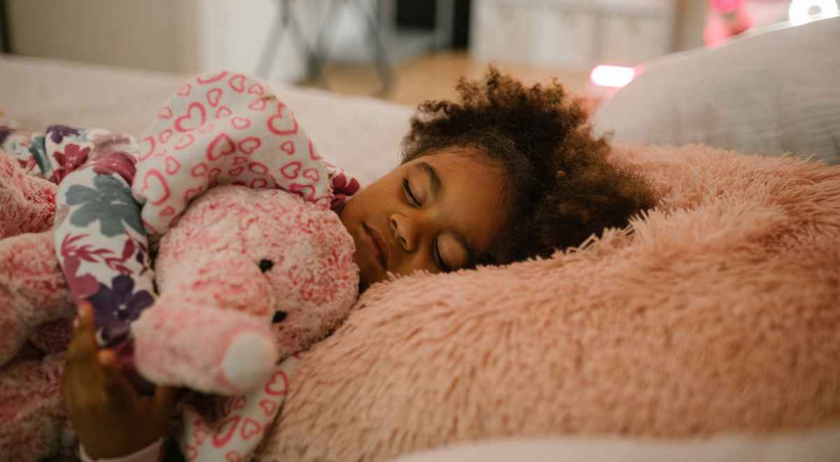 Girl child sleeping hugging her soft toy