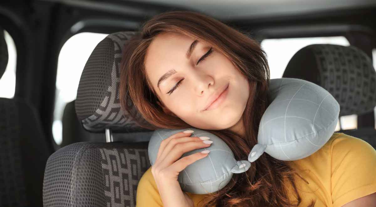 woman with a travel neck pillow travelling in a car