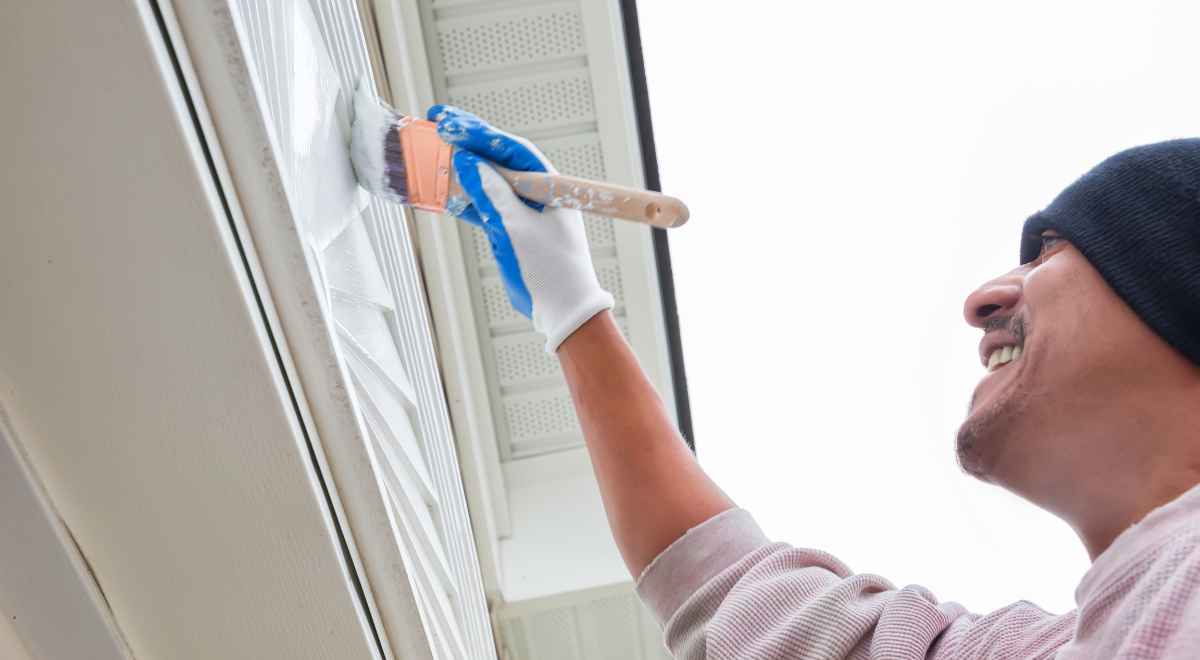 person painting his home exterior 