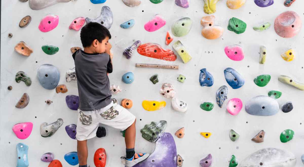 kid climbing a climbing wall