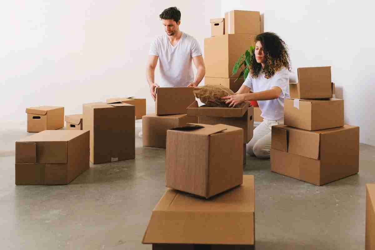 focused-young-couple-packing-carton-boxes-before-relocation