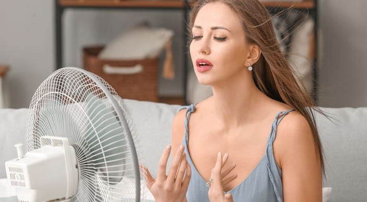 Woman cooling off with the help of a table fan