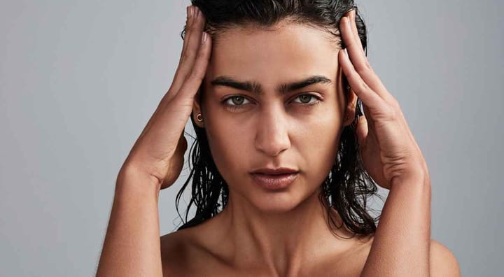 A girl posing for picture keeping her hands on her head