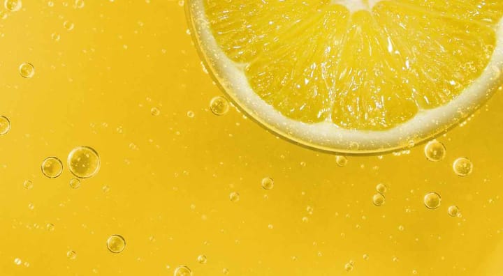 cut Lemon in a yellow background with water molecules on it