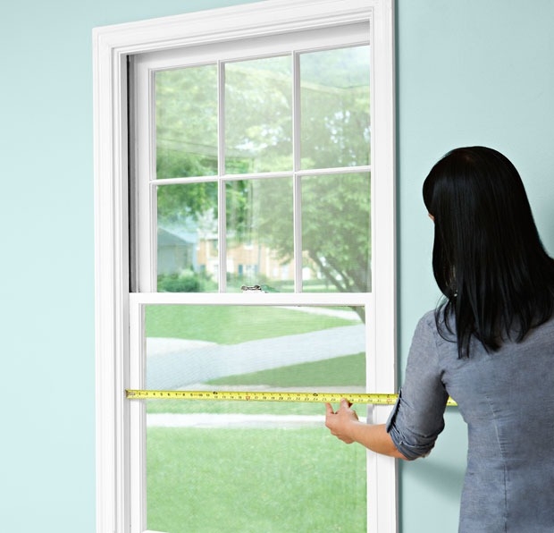 a woman measuring windows