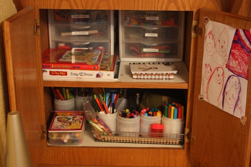 Children's school items neatly arranged in a cabinet