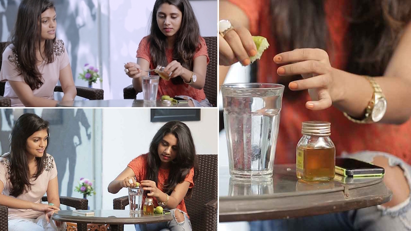 lemon being squeezed into a glass of water