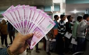 man holding a wad of 2000 rupee notes in a bank