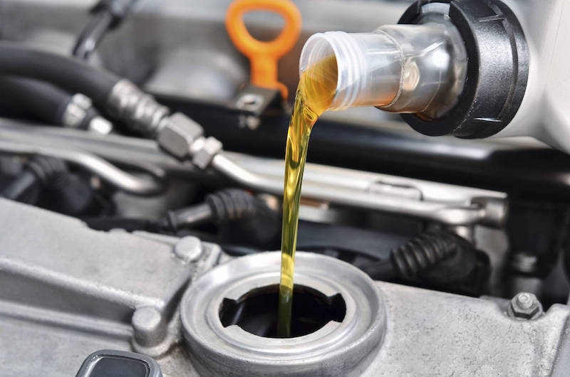 pouring oil into vehicle engine