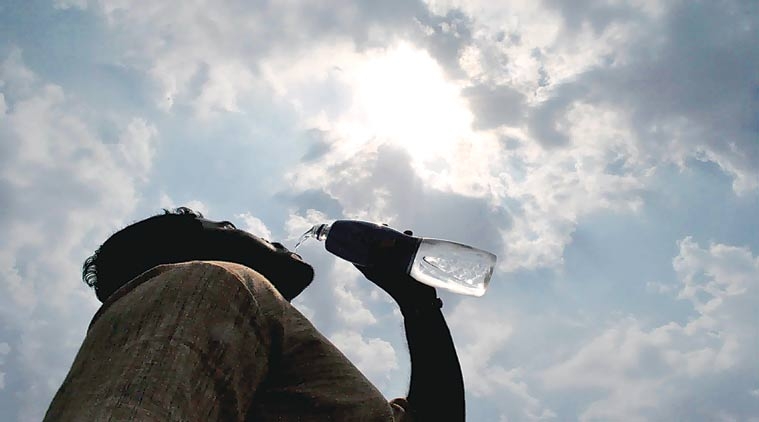 man drinking water on a scorching day