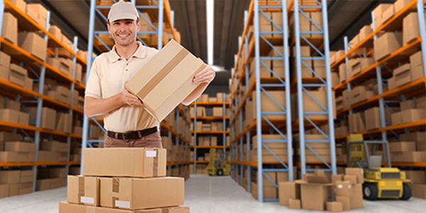 A man holding up a package in a warehouse facility