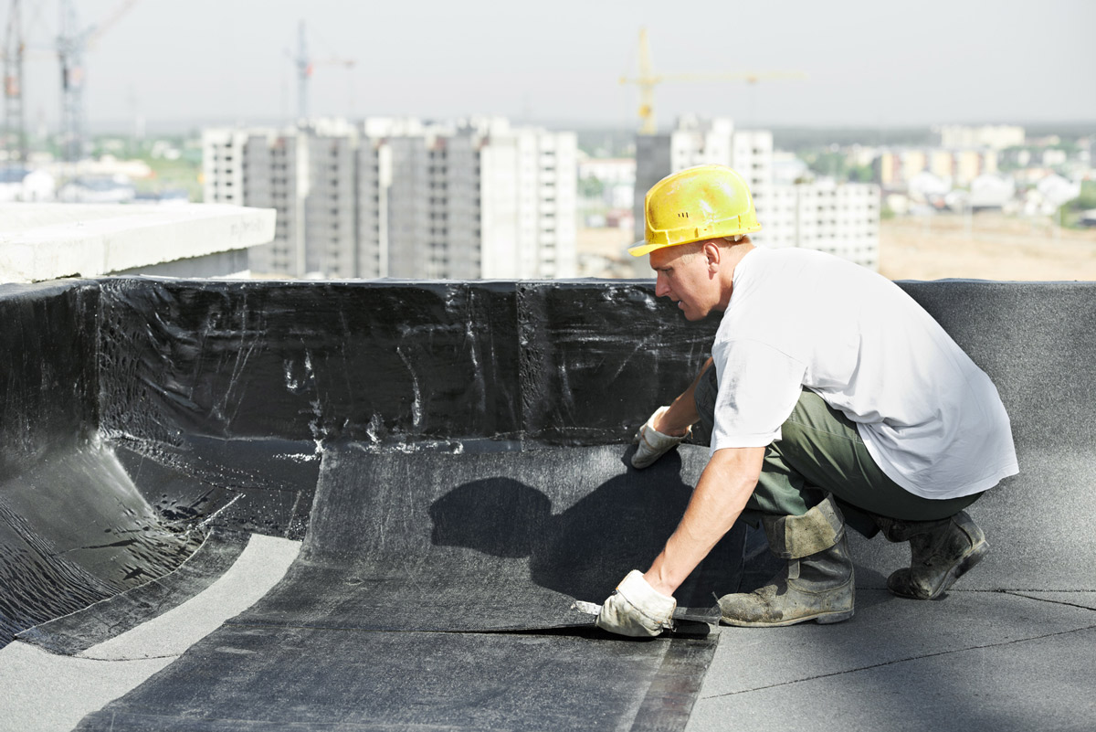 Waterproofing specialist applying roof membrane in India