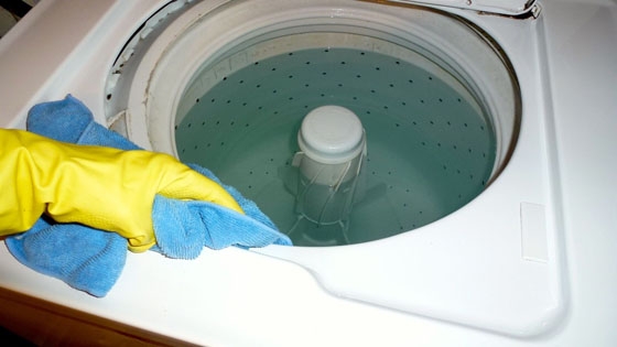person cleaning the drum of a washing machine