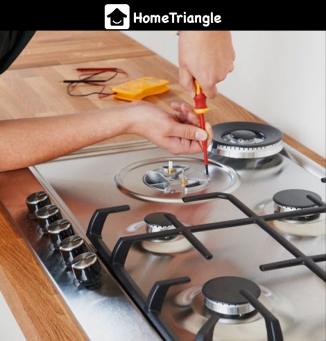 man operating on gas stove with screwdriver