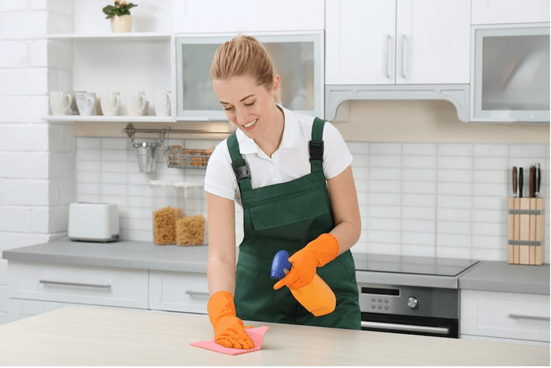 a woman cleaning a kitchen table